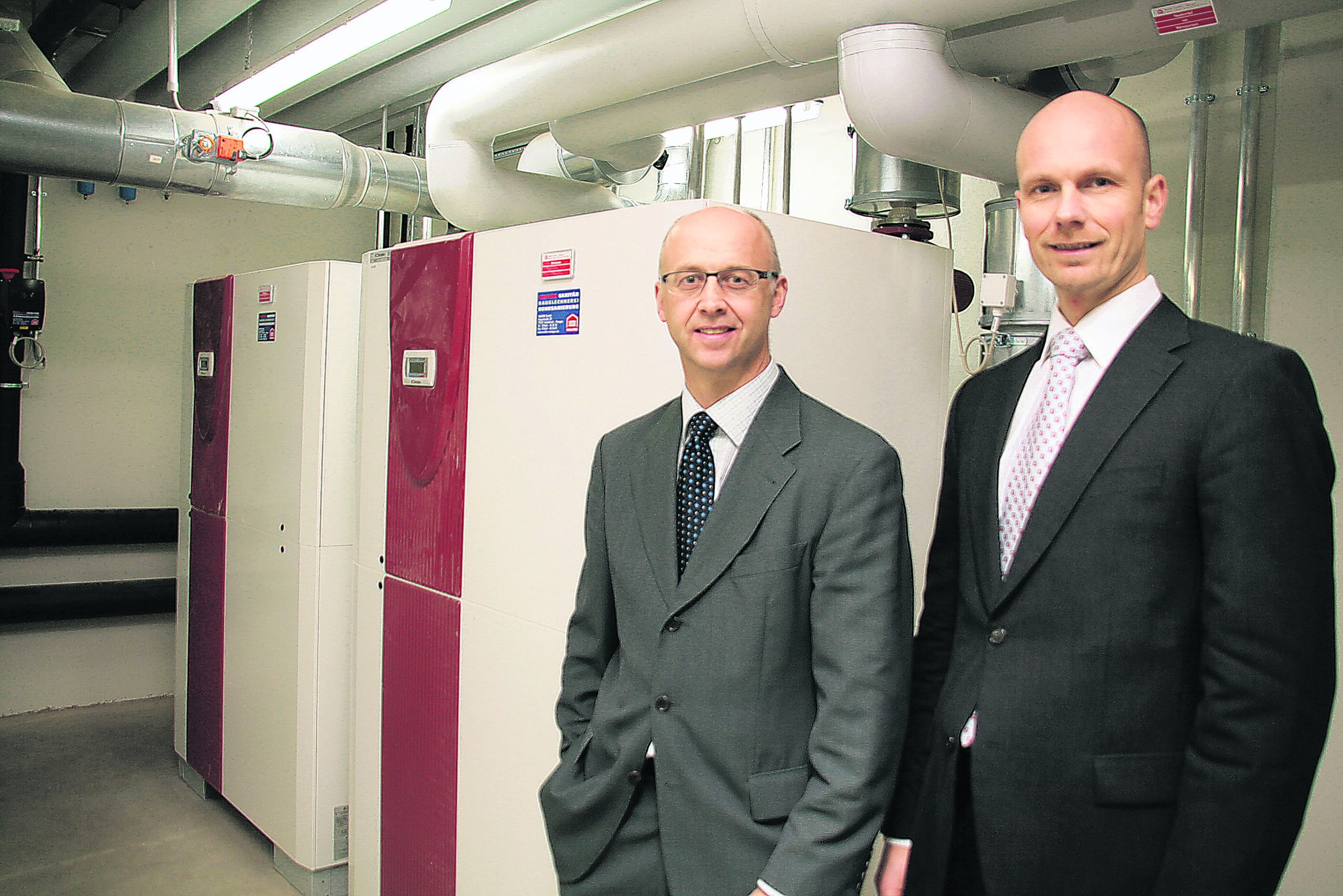 Zwei Mitarbeiter präsentieren die Wärmepumpenanlage der Emil Frei GmbH & Co. KG