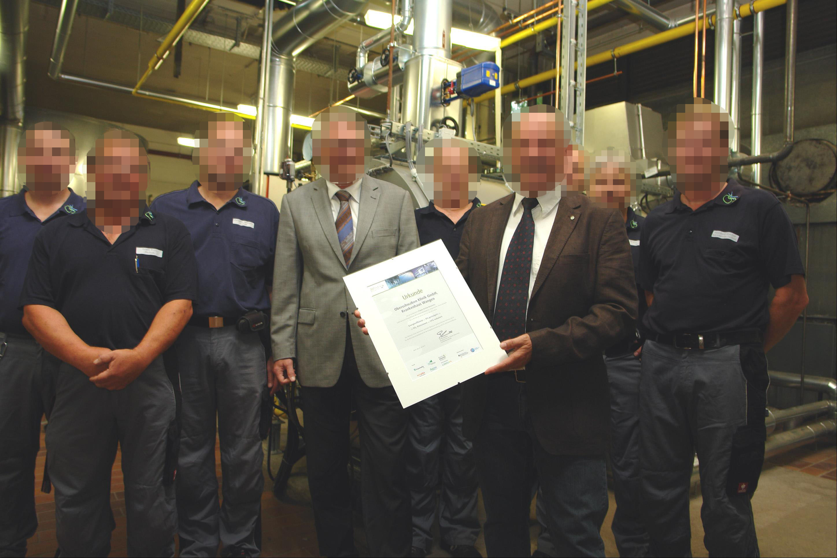 Mitarbeitende präsentieren eine Urkunde